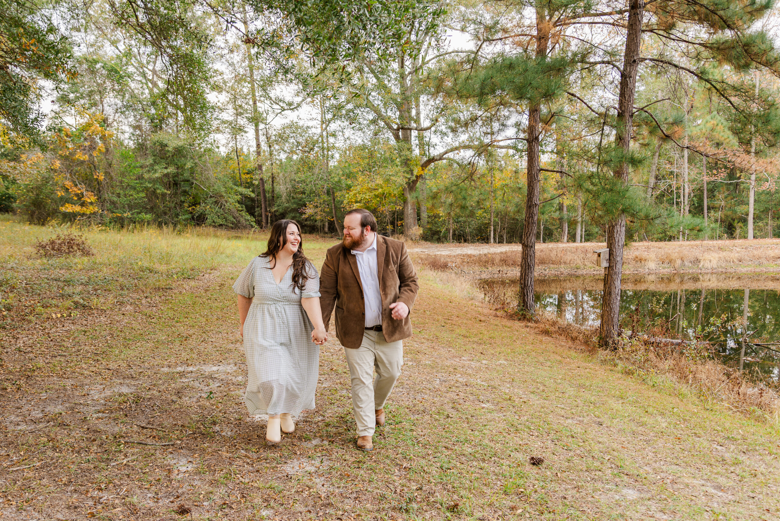 Couple holding hands while looking at each other and walking towards the camera