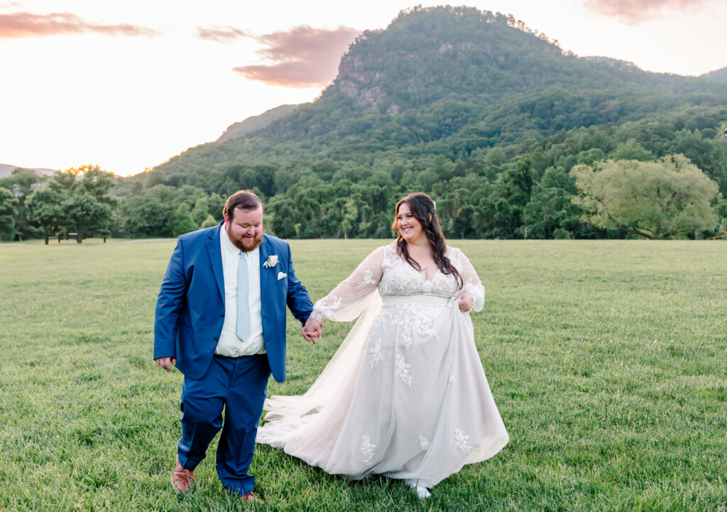 Bride and groom walking at sunset with the  mountains behind them.