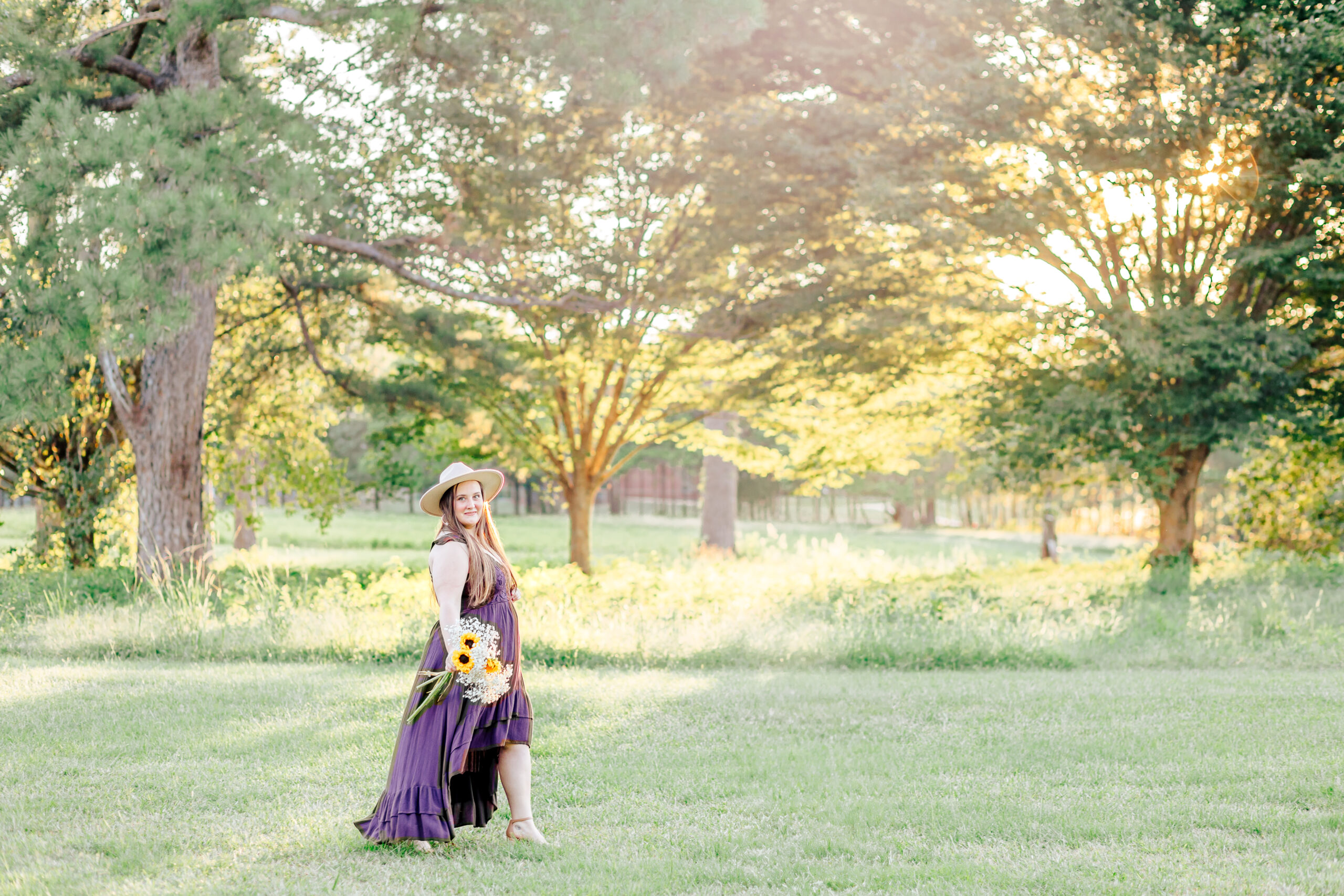 A young woman walking in a field at sunset holding flowers as she moves on after a canceled wedding