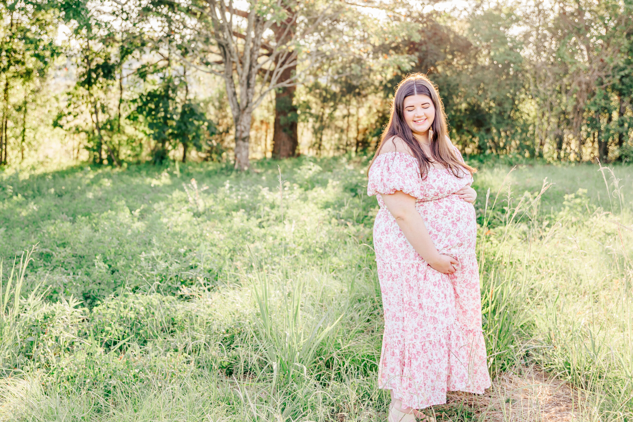 Kennedy, a University of Alabama student, gently cradles her baby bump during golden hour at the Tuscaloosa Arboretum, radiating strength and grace as she prepares for motherhood.