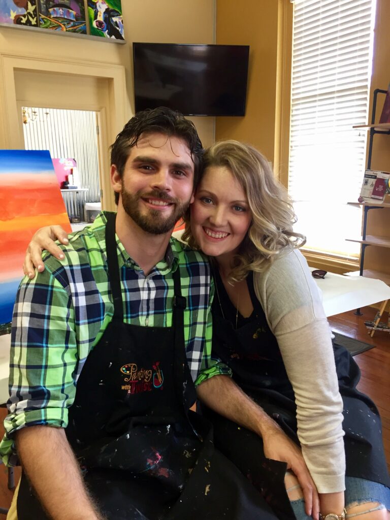 Photo of couple taking an art class together; unique date idea 