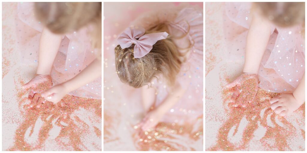 Close up photo of little girl playing in pink and gold glitter and putting glitter in her hand 