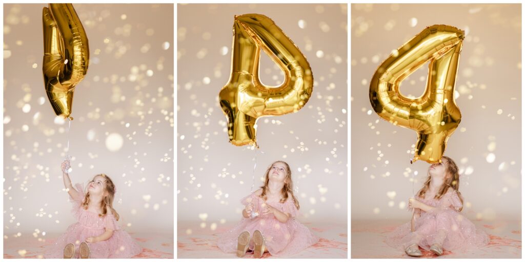 Little girl in a pink dress looking at the camera and laughing while she holds a large number 4 balloon as glitter falls down 