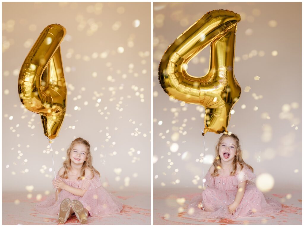 Little girl in a pink dress looking at the camera and laughing while she holds a large number 4 balloon as glitter falls down for a glitter birthday photoshoot 