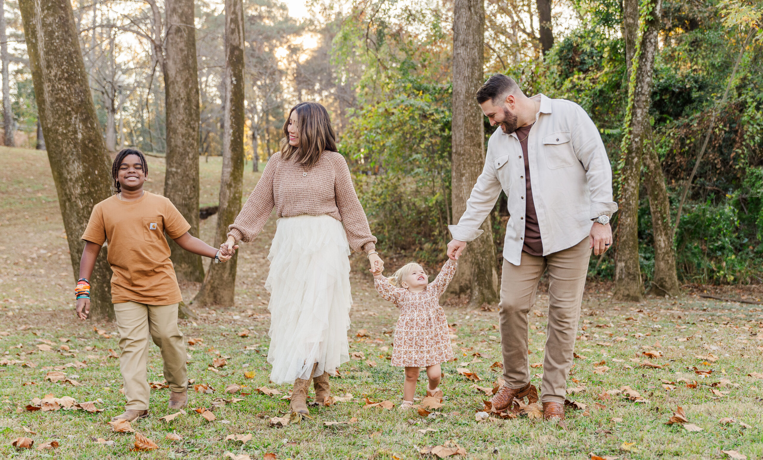 Outdoor autumn family photo with parents and kids wearing cozy neutral layers.