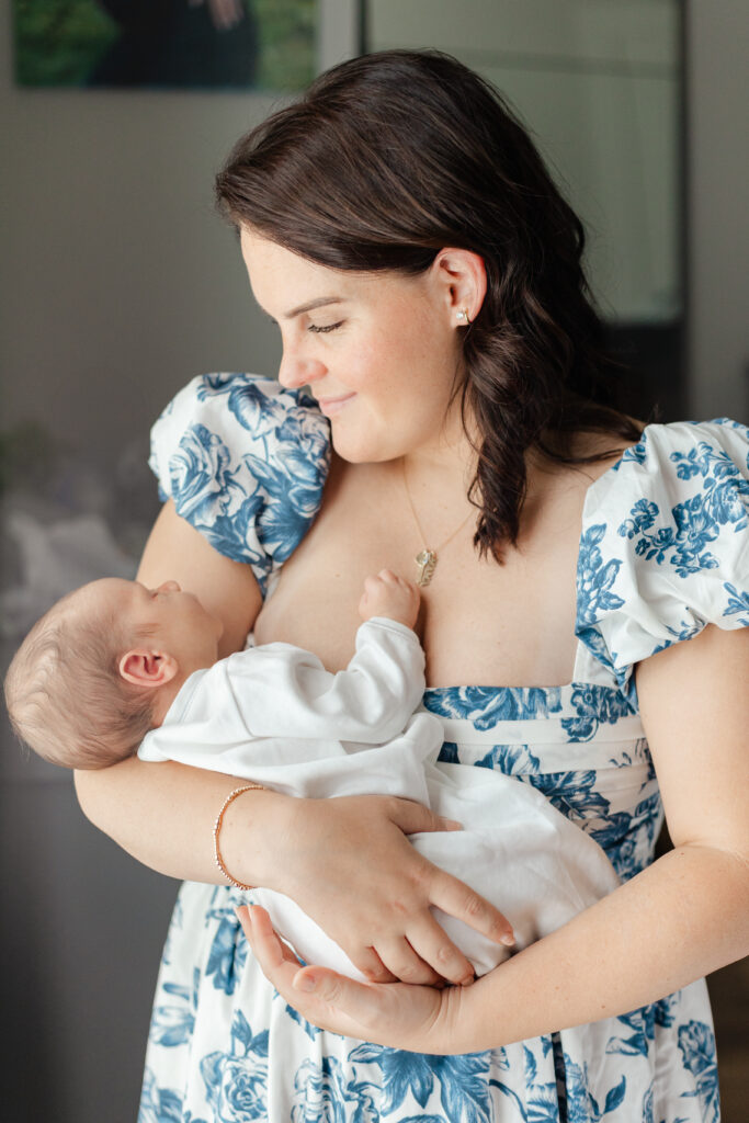 Mother holding newborn in natural light, showcasing emotional connection at home