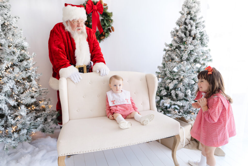 A toddler taking her time to warm up as Santa waits patiently at a Tuscaloosa Santa mini session