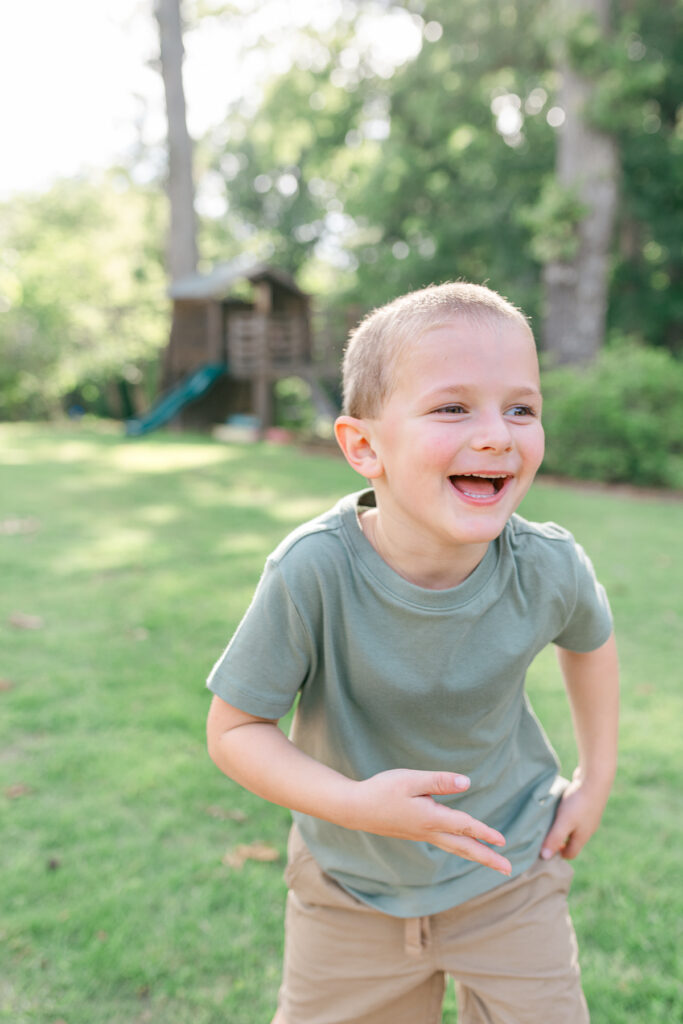Little boy caught laughing during a Northport summer family photo session.