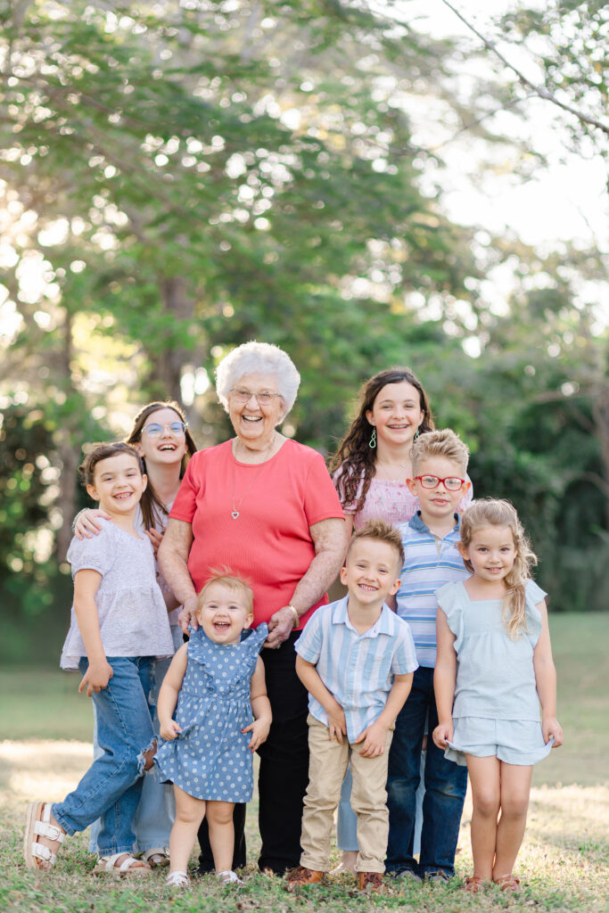 Grandmother laughing with her great grandchildren during a multigenerational family photo session
